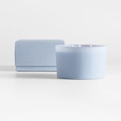 a white candle sitting next to a blue box