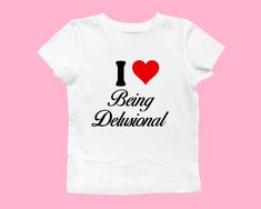 I heart being delusional baby tee ❤️ ♡ Please let me know if you need any custom designs that is not listed, I'll happily custom-make it for you! ♡ 🌟SIZING Please find the size chart in listing photo before purchasing. We recommended measuring a t-shirt you already own to get the best fitting t-shirt.  💖CARE/ WASH Machine wash: warm (max 40C or 105F); Non-chlorine: bleach as needed Tumble dry: medium heat; Iron, steam or dry: low heat; Do not dry clean. ✨SHIPPING Custom orders may take longer I Love T-shirt, Baby Tee Sayings, I Heart T Shirt, Baby Tee Outfit Aesthetic, I Heart Shirts, I Love Being Delusional, Love Being Delusional, I Love Shirts, Being Delusional