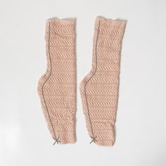 two pink knitted mittens sitting next to each other