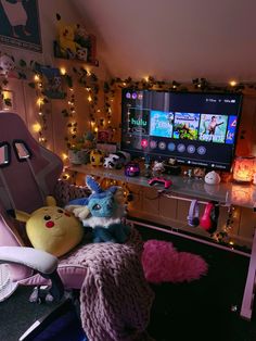 some stuffed animals are sitting in front of a television set with lights on the wall