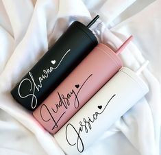 three personalized travel mugs sitting on top of a white blanket