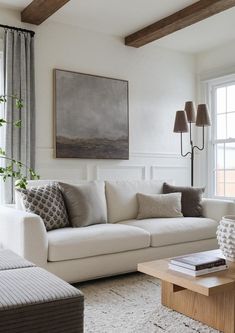 a living room filled with furniture and a large painting hanging on the wall above it