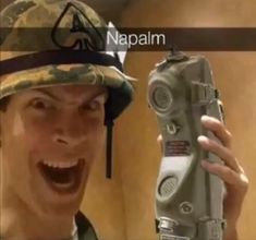 a man in camo hat holding up an old fashioned radio to take a selfie