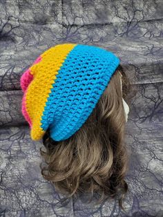 a close up of a person wearing a knitted hat with two colors on it