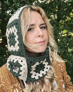 a woman with blonde hair wearing a green crocheted hat and neckwarf