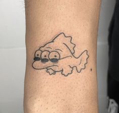 a man's arm with a cartoon character tattoo on the left side of his wrist