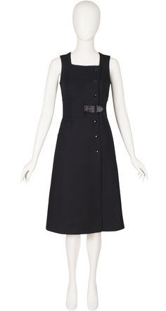 "This late-1960s/early-1970s Courrèges Couture Future sleeveless A-line dress was made in France of black ribbed 55% dralon/45% wool and originally sold at Harrods. It's numbered \"040865.\" It has a rayon lining, and a pocket on the right side. It fastens with six snaps in the front and a vinyl buckle at the waist. There's some wear to the vinyl buckle but it's otherwise in excellent condition. It has been professionally dry-cleaned and is ready to wear. Measurements: Bust - 33\" Waist - 29\" H Retro Sleeveless Evening Midi Dress, Retro Sleeveless Midi Dress For Evening, Classic Sleeveless Vintage Dress, Black Sleeveless Vintage Midi Dress, Vintage Black Sleeveless Midi Dress, 1950s Style Black Sleeveless Dress, 1950s Style Sleeveless Black Dress, Black Sleeveless 1950s Style Dress, Courreges Robe