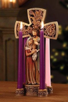 three candles with an image of the virgin and child on them in front of a christmas tree