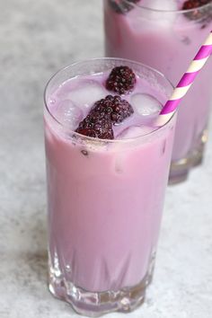 two glasses filled with ice and raspberries next to each other