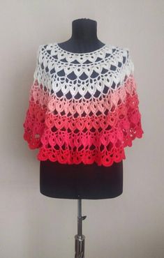 a white and pink crocheted shawl on a mannequin