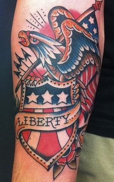 an eagle and flag tattoo on the arm with words liberty written in red, white and blue