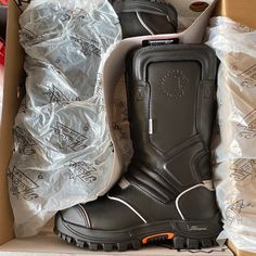 a pair of black boots sitting inside of a box