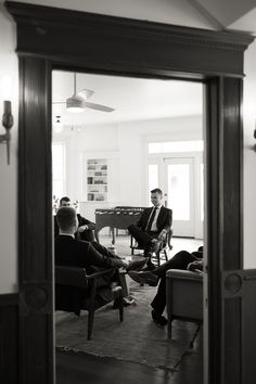 black and white photograph of two men sitting on chairs in front of a grand piano