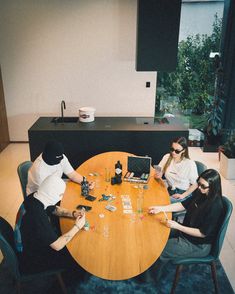 three people sitting at a table playing cards