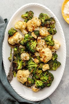 a white plate topped with broccoli and cauliflower