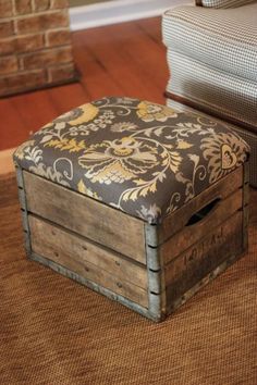 a wooden box sitting on top of a brown rug next to a chair and ottoman