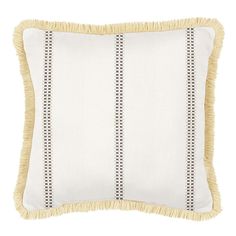 a white and yellow pillow with fringe trim