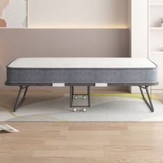 a mattress is sitting on the floor in front of a book shelf