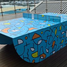 a ping pong table is painted with an artistic pattern on the top and bottom