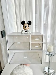 a mickey mouse stuffed animal sitting on top of a dresser