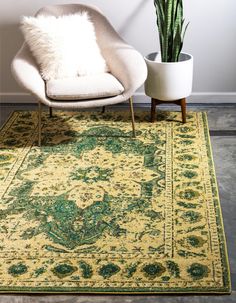 a green and yellow area rug with a chair, potted plant and white wall in the background