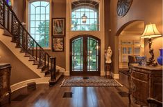 an entryway with stairs and pictures on the wall, along with wooden flooring