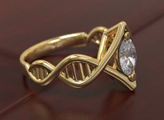 a gold ring with a white diamond on it's side and an intertwined band