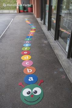 a long line of colorfully painted letters on the ground in front of a building