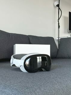 a pair of ski goggles sitting on top of a bed next to a box