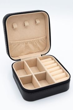 an open black case with multiple compartments on the top and bottom, sitting on a white surface