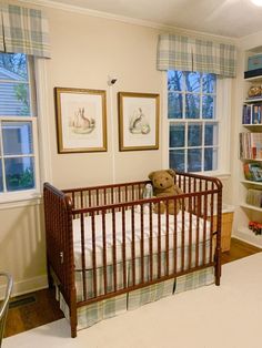 a baby's room with a crib, bookshelf and two windows