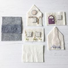 four felt houses are displayed on a white table