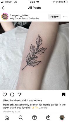 a small tattoo on the arm of a woman with holly leaves and an olive branch