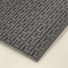 a close up view of a gray carpet on a white surface with no people around it