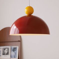 a red and yellow light hanging from a wooden headboard next to a framed photograph