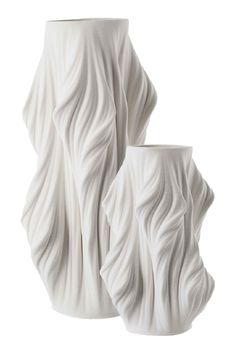 two white vases sitting next to each other on a white surface with wavy lines