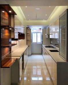 a long narrow kitchen with white counter tops and wooden cabinets on either side of the room