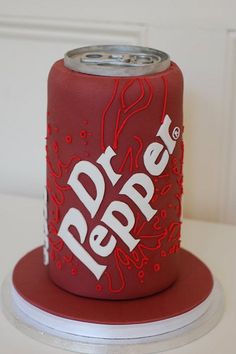 a red can cake with white writing on it