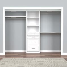 an empty closet with white shelves and drawers on the floor, in front of a gray wall