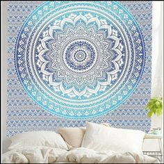 a large blue and white tapestry hanging on the wall above a bed in a bedroom