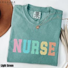 The Comfort Colors® Retro Nurse Shirt features a vibrant, multi-colored "NURSE" design in a classic block font, evoking a nostalgic and playful style. This shirt is ideal for nurses who want to show off their profession with a fun twist. It's perfect for everyday wear or as a thoughtful gift for nursing students, RN's, or nurse graduates. The relaxed fit and soft fabric make it a comfortable choice for both work and leisure, while the vintage-inspired print adds a unique flair. This tee is a sty Nurse Design, Nursing Student Gifts, School Tees, Letter Design, Nurse Shirt, Holiday Shirt, Inspirational Shirt, Nursing Shirts, Holiday Shirts