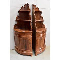 two wooden bookcases sitting next to each other on top of a white floor