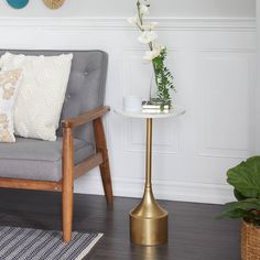 a living room scene with focus on the chair and table that has flowers in it