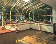 a large kitchen with lots of windows and wooden flooring, along with an island in the middle