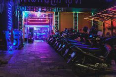 several motorcycles parked in front of a building with christmas lights on the walls and doors