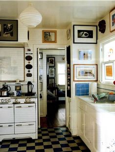 an old fashioned kitchen with black and white checkerboard flooring on the walls