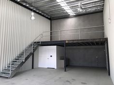 an empty garage with stairs and metal walls