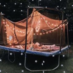 a tent is set up in the grass with lights on it and stars all around