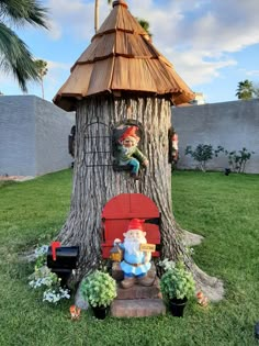 a gnome sitting on top of a red chair next to a tree