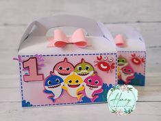 two little boxes with pink bows on them and one has an image of baby shark